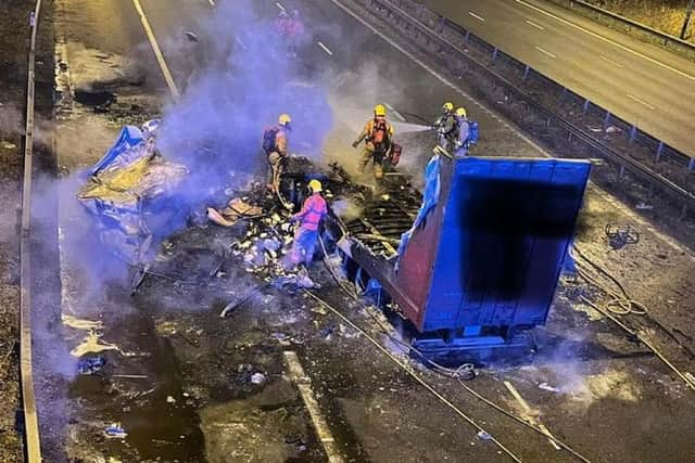 A lorry burst into flames after strong winds caused it to crash into a motorway bridge on the M6 between Preston and Wigan.