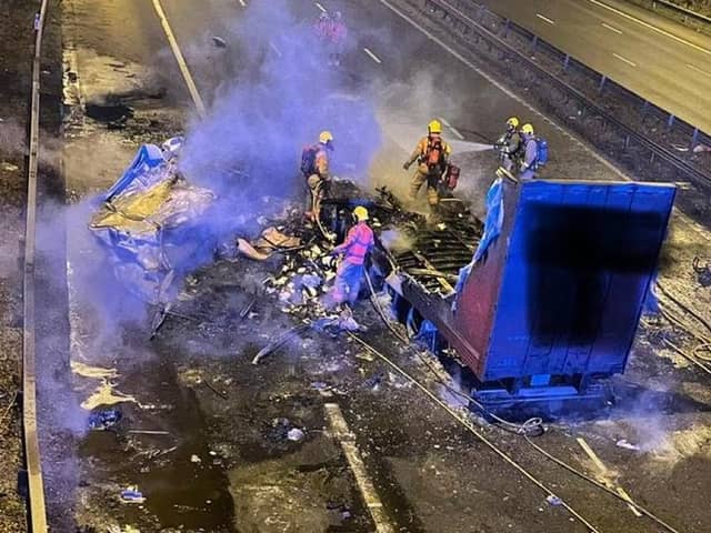 A lorry burst into flames after strong winds caused it to crash into a motorway bridge on the M6 between Preston and Wigan.
