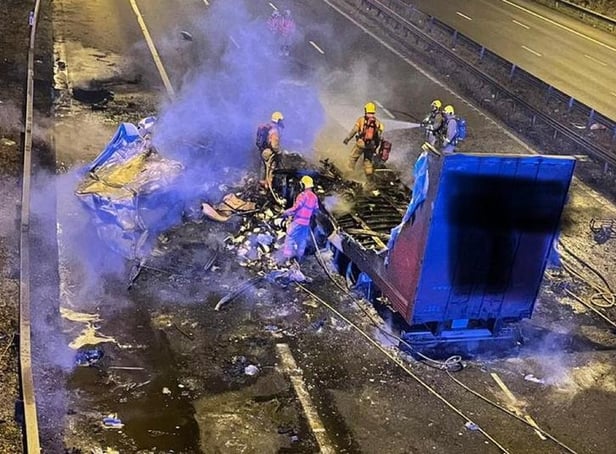 A lorry burst into flames after strong winds caused it to crash into a motorway bridge on the M6 between Preston and Wigan.