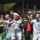 The Latics side celebrate in front of the away end at Wycombe