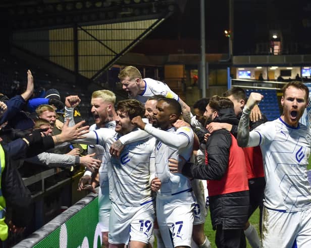 The Latics side celebrate in front of the away end at Wycombe