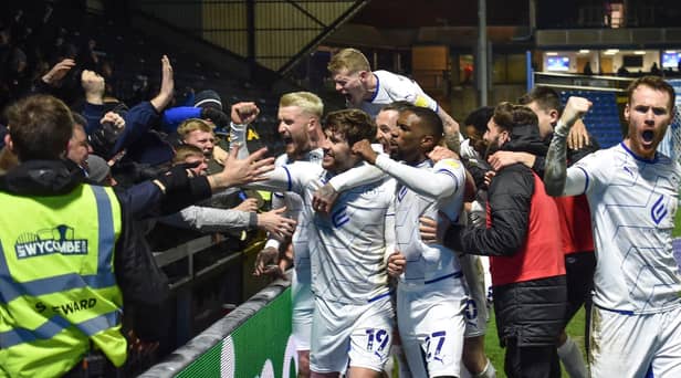 The Latics side celebrate in front of the away end at Wycombe