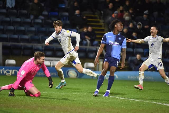 Callum Lang wheels away in delight after scoring his second and Latics' third goal