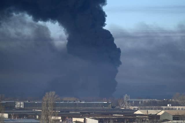 Black smoke rises from a military airport in Chuguyev near Kharkiv on February 24, 2022. - Russian President Vladimir Putin announced a military operation in Ukraine today with explosions heard soon after across the country and its foreign minister warning a "full-scale invasion" was underway.