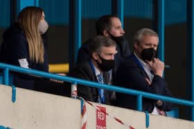 Mal Brannigan (second left) watches the recent match at Gillingham