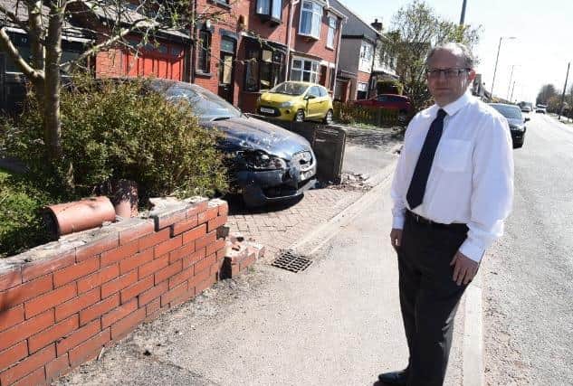 Coun Michael Winstanley looks at damage caused to a wall after the smash on Winstanley Road, Orrell