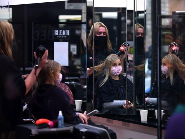 A customer has her hair dried following a haircut inside a hairdresser's salon in London