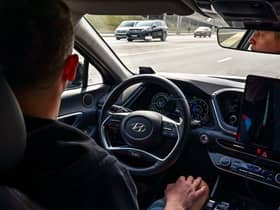 A picture taken on April 15, 2021 shows engineer Alexey keeping his hands on his knees as the self-driving car, developed by Russian internet giant Yandex, moves along a road in Moscow