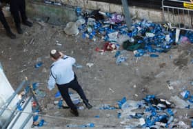 A police officer walks at the scene where dozens were killed in a crush at a religious festival in Mount Meron on April 30, 2021 in Meron, Israel. At least 44 people were crushed to death and over 150 more injured in a stampede, as tens of thousands of ultra-Orthodox Jews gathered to celebrate the Lag B'omer event, late Thursday. (Photo by Amir Levy/Getty Images)