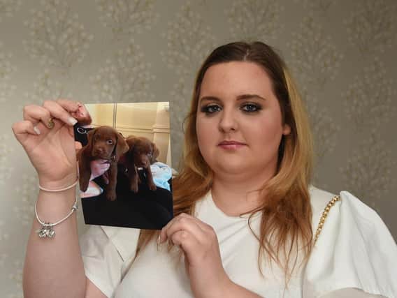 Ellie-May Willan, from Orrell, holding a picture of the two puppies which died