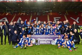 Staff and coaches join the Latics Under-18s in celebrating the national title