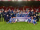 Staff and coaches join the Latics Under-18s in celebrating the national title