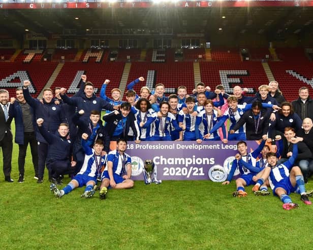 Staff and coaches join the Latics Under-18s in celebrating the national title