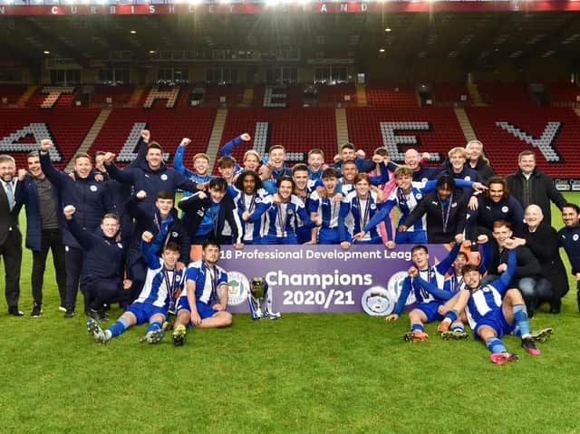 Staff and coaches join the Latics Under-18s in celebrating the national title