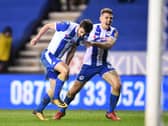 Will Grigg celebrates his winning goal against Manchester City in the FA Cup with Max Power