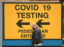A pedestrian walks past a sign directing members of the public to a Covid-19 testing centre in Bolton,