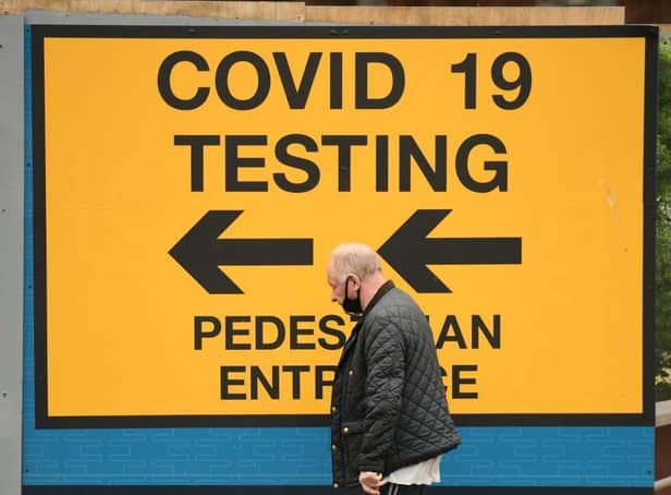 A pedestrian walks past a sign directing members of the public to a Covid-19 testing centre in Bolton,