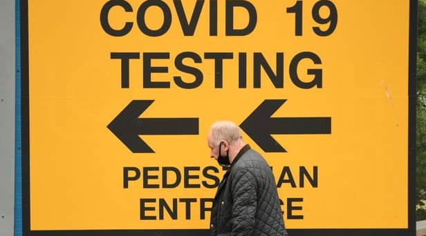 A pedestrian walks past a sign directing members of the public to a Covid-19 testing centre in Bolton,