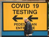 A pedestrian walks past a sign directing members of the public to a Covid-19 testing centre in Bolton,