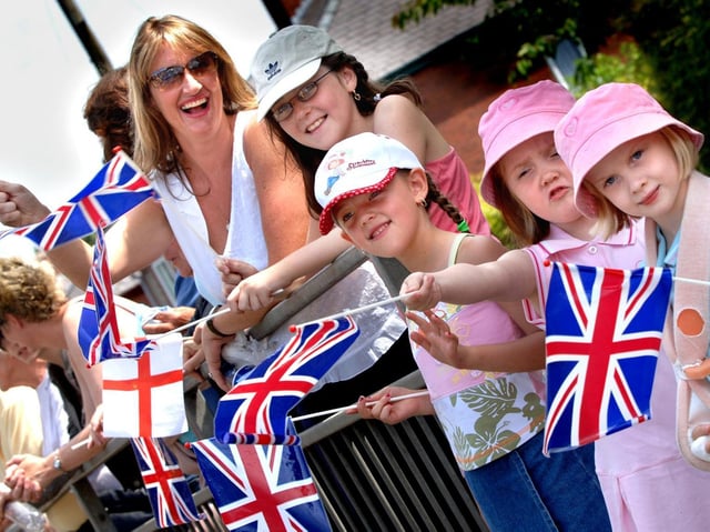 Crowds wave their flags as the VE Day parade passes in Standish, 2005.