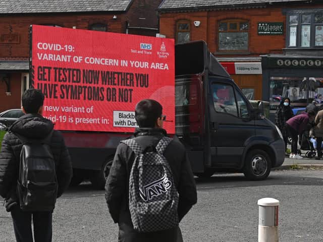Information advising people to get tested due to the prevalence of a coronavirus covid-19 variant is displayed on a screen attached to a vehicle on the streets of Blackburn.