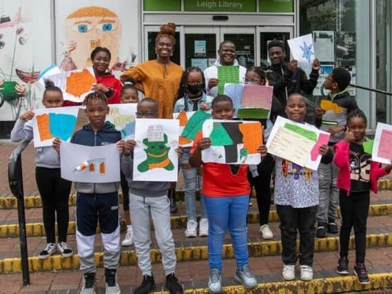 Artist Ibukun Baldwin with young people and their art for the exhibition