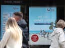 People make their way past the shop window of a Tui store