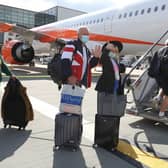 Passengers prepare to board an easyJet flight to Faro, Portugal, at Gatwick Airport