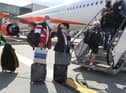 Passengers prepare to board an easyJet flight to Faro, Portugal, at Gatwick Airport