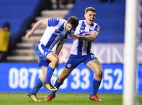 Wil Grigg celebrates his winning goal against Manchester City with Max Power