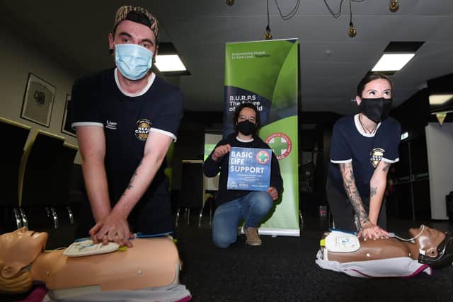 Liam Hook, Ben Cusick and Sophie Nicholson try out the CPR training course