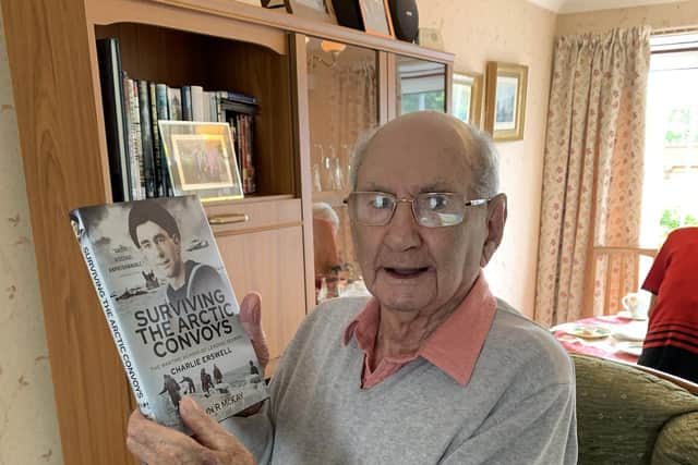 WW2 veteran Leading Seaman Charlie Erswell holding a copy of his memoirs