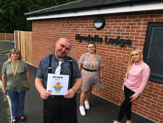 David Clarke a resident at Hyndelle Lodge supported living, Hindley, was struggling with reading but with the help of staff he has now written a book. David pictured with support workers Gill Melling, left, Kayleigh McGarrigan and Ellie Nugent, right