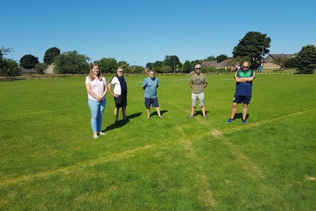 Councillors and members of Aspull Juniors FC looking at the pitch damage