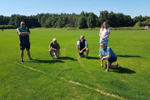 Councillors and members of Aspull Juniors FC inspecting the tyre marks