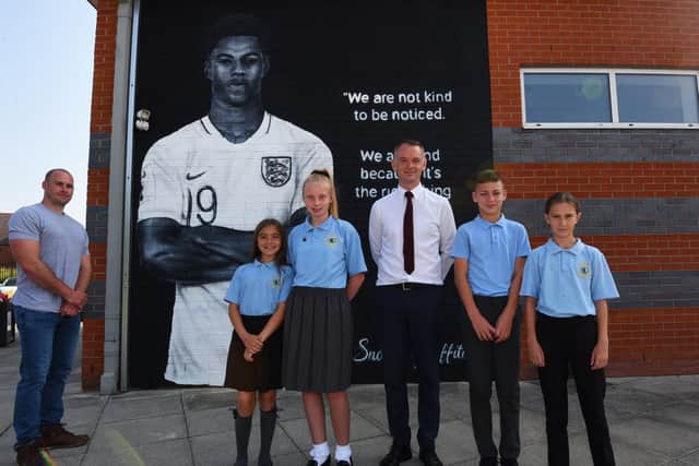 Artist Scott Wilcock, headteacher Stephen Wallace and pupils with the mural