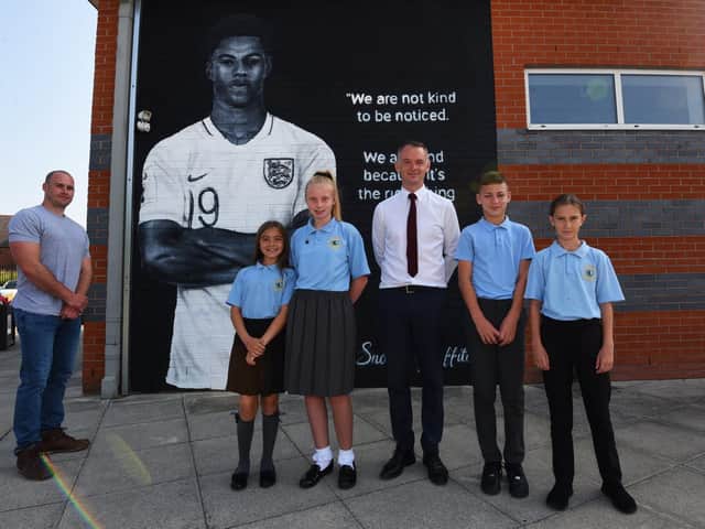 Artist Scott Wilcock, headteacher Stephen Wallace and pupils with the mural