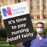 A Nurse with a placard outside the Royal College of Nursingin Victoria Tower Gardens, London