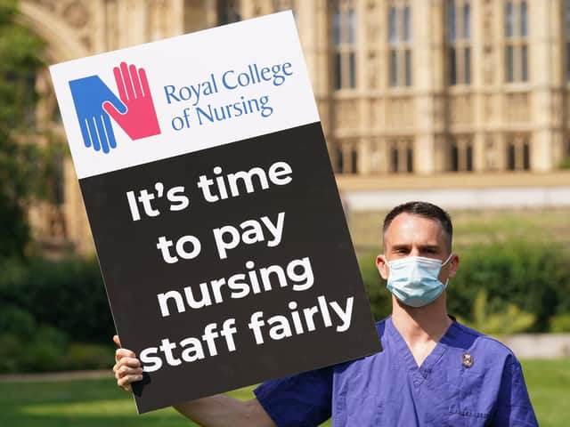 A Nurse with a placard outside the Royal College of Nursingin Victoria Tower Gardens, London