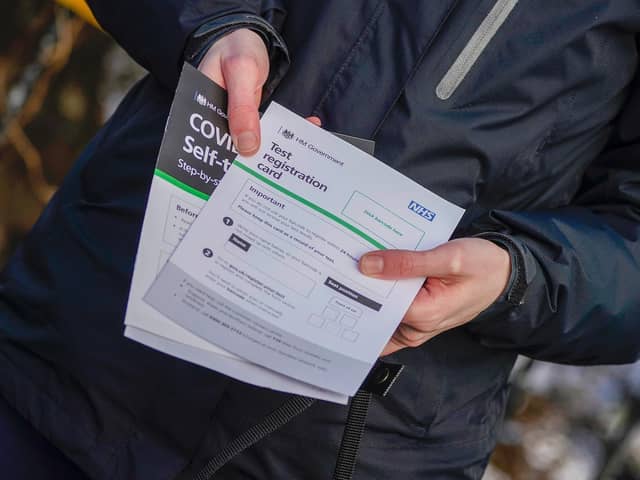 A person poses with their Test registration card after being tested at Our Lady's RC Church in Moss Side.