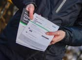 A person poses with their Test registration card after being tested at Our Lady's RC Church in Moss Side.