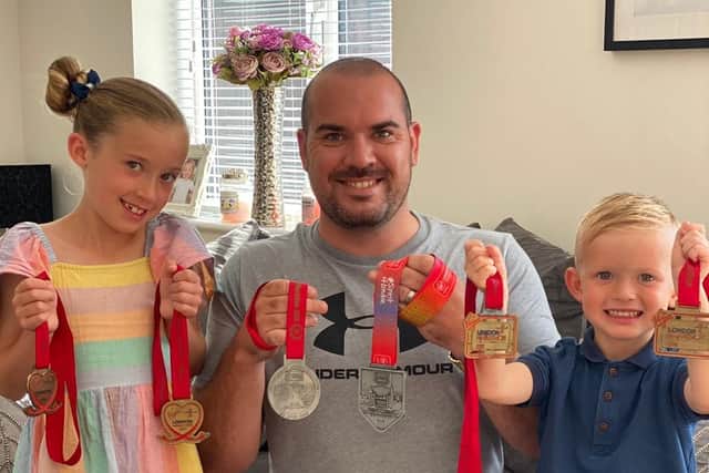Jon Leggott with his children Amelie and Jacob holding some of his medals