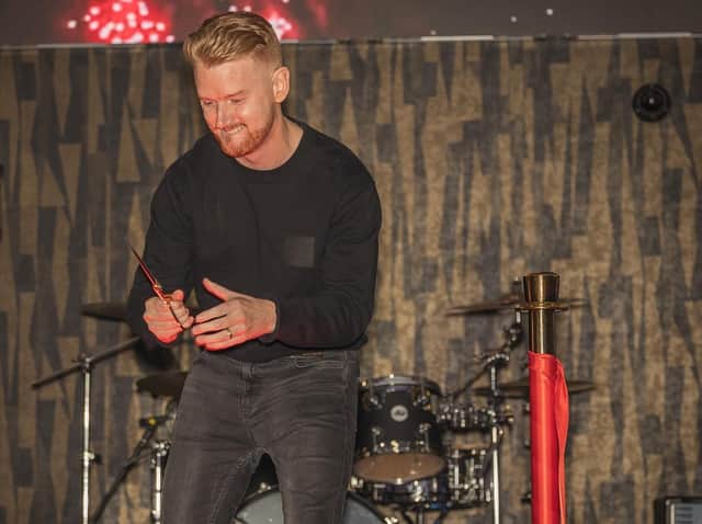 Mikey North cuts the ribbon