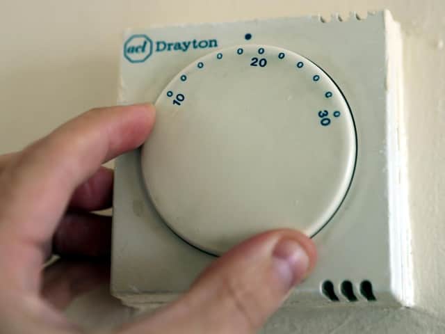 A gas central heating thermostat being adjusted.