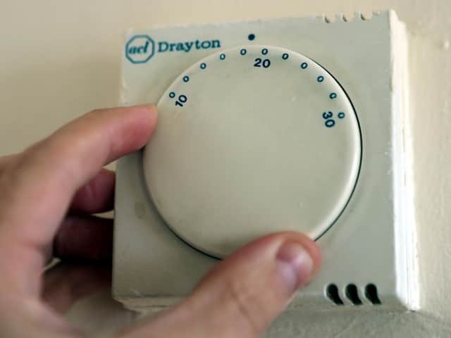 A gas central heating thermostat being adjusted.