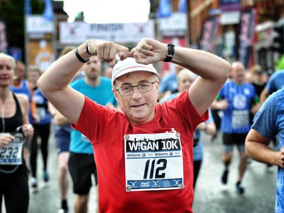 A runner does the "Joining Jack salute" during 2019's Wigan 10k