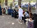 Internally displaced Afghan families, who fled from Kunduz and Takhar province due to battles between Taliban and Afghan security forces, eat their lunch at the Shahr-e-Naw Park in Kabul on August 10, 2021