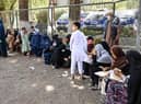 Internally displaced Afghan families, who fled from Kunduz and Takhar province due to battles between Taliban and Afghan security forces, eat their lunch at the Shahr-e-Naw Park in Kabul on August 10, 2021