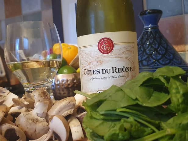 A glass of Côtes-du-Rhône Blanc, Guigal, as the creamed mushrooms and spinach is prepared