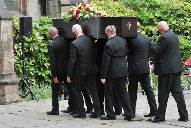 The coffin is carried into Leigh Parish Church